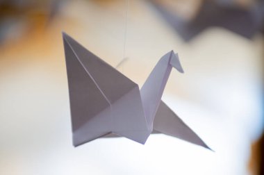 Japanese folded Origami cranes hanging on with strings. Hundreds handmade paper birds isolated with copy space. 1000 thousand crane tsuru sculpture topic. Symbol of peace, faith, health, wishes, hope