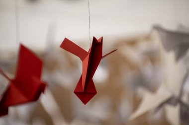 Japanese folded Origami cranes hanging on with strings. Hundreds handmade paper birds isolated with copy space. 1000 thousand crane tsuru sculpture topic. Symbol of peace, faith, health, wishes, hope