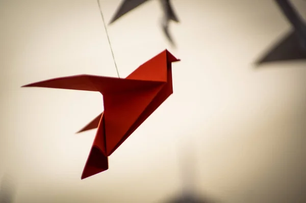 Japanese folded Origami cranes hanging on with strings. Hundreds handmade paper birds isolated with copy space. 1000 thousand crane tsuru sculpture topic. Symbol of peace, faith, health, wishes, hope