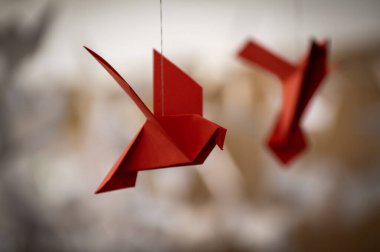 Japanese folded Origami cranes hanging on with strings. Hundreds handmade paper birds isolated with copy space. 1000 thousand crane tsuru sculpture topic. Symbol of peace, faith, health, wishes, hope