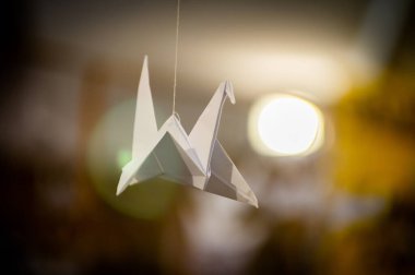 Japanese folded Origami cranes hanging on with strings. Hundreds handmade paper birds isolated with copy space. 1000 thousand crane tsuru sculpture topic. Symbol of peace, faith, health, wishes, hope