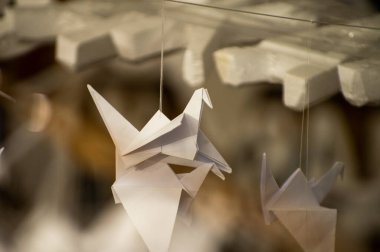 Japanese folded Origami cranes hanging on with strings. Hundreds handmade paper birds isolated with copy space. 1000 thousand crane tsuru sculpture topic. Symbol of peace, faith, health, wishes, hope