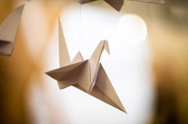 Japanese folded Origami cranes hanging on with strings. Hundreds handmade paper birds isolated with copy space. 1000 thousand crane tsuru sculpture topic. Symbol of peace, faith, health, wishes, hope