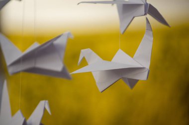 Japanese folded Origami cranes hanging on with strings. Hundreds handmade paper birds isolated with copy space. 1000 thousand crane tsuru sculpture topic. Symbol of peace, faith, health, wishes, hope