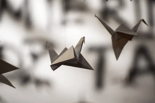 stock image Japanese folded Origami cranes hanging on with strings. Hundreds handmade paper birds isolated with copy space. 1000 thousand crane tsuru sculpture topic. Symbol of peace, faith, health, wishes, hope