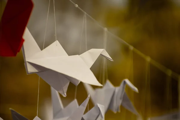 stock image Japanese folded Origami cranes hanging on with strings. Hundreds handmade paper birds isolated with copy space. 1000 thousand crane tsuru sculpture topic. Symbol of peace, faith, health, wishes, hope