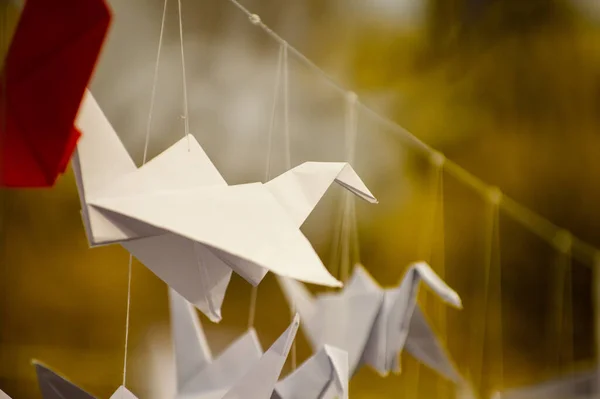 stock image Japanese folded Origami cranes hanging on with strings. Hundreds handmade paper birds isolated with copy space. 1000 thousand crane tsuru sculpture topic. Symbol of peace, faith, health, wishes, hope