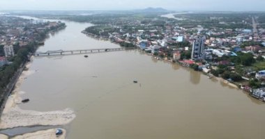 Nehir kıyısı genişliğini arttırmak için geriye dönük kumlu hava aracı görüntüleri. Kampot şehri arka planda. 