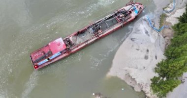 Nehir kıyısı genişliğini arttırmak için bir tarama teknesinin tepeden drone görüntüsü.