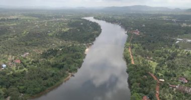 aerial drone shot of the Praek Tuek Chhu river with clouds in sky reflected in water 