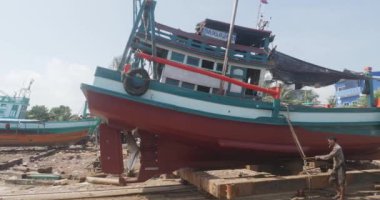Sihanoukville, Kamboçya - 05.12.2023: Tersaneden ayrılan balıkçı teknesinin yan görüntüsü ve onarıldıktan sonra denize dönmesi