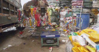 Sihanoukville, Kamboçya - 05.12.2023: küçük kamyona yüklenmeden önce sıkıştırılmış atık plastik kübünün ağırlığı yakın çekim 