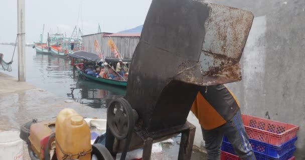 カンボジアのシアヌークビル 2023年 粉砕機で氷の労働者の破砕ブロックの側面図 背景に漁船 — ストック動画