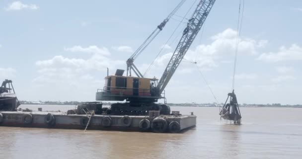 装在驳船上的桶式挖掘机把泥沙从河流的一个地方运走 再把它放回河的另一个地方 — 图库视频影像