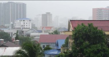 Sihanoukville kasabasının bir mahallesinde hafif bir yağmur ve arka planda yoğun bir sis var.