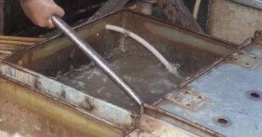 Metal kutudan balık toplamak için ağı kullanan bir satıcıyı kapat. 