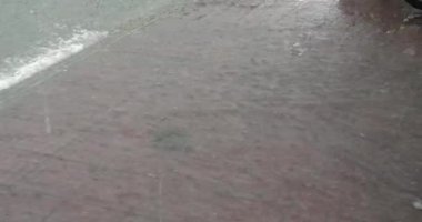 Şiddetli yağmurun altında bir kaldırım taşar.