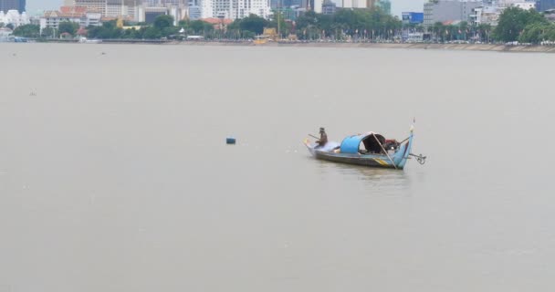 漁船に座っている漁師が川から漁網を引き上げる — ストック動画