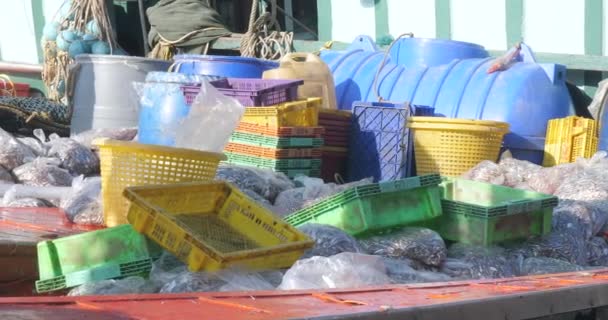 釣り港のドック 木枠およびバスケットのプラスチック袋が積まれたボビングの釣りのボートの近く — ストック動画