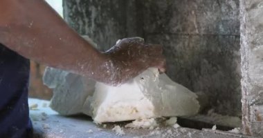 Bir adamın yoğurma makinesine pirinç hamuru attığı yakın çekim..