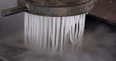  Erişteleri kaynar suya boşaltan bir makineye yakın dur.,