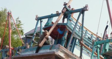 Sihanoukville - Kamboçya - 02.17.2024; işçilerin kapatılması kayıkhanedeki balıkçı teknesine korkuluk kuruyor. 