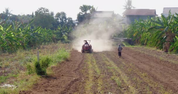 トラクターを使用して土地を植え ほこりのない環境を作成する農家のフロントビュー — ストック動画