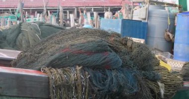 Ağlar ve halatlar yığını kapanıyor. İskeleye varan balıkçı teknesinin güvertesinin büyük bir kısmını gizliyor.