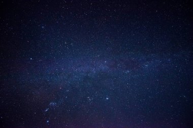 Gece bulutsuz gökyüzü. Parlayan yıldızların takımyıldızları ve galaksileri oluşturduğunu görebilirsiniz..
