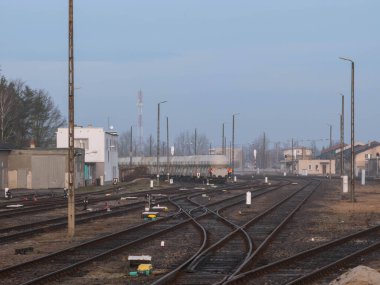 Polonya 'nın Zagan kentindeki tren istasyonu. İstasyona giden ve ayrılan sayısız demiryolu hattı katılımcıları oluşturuyor. Demiryolu anahtarlarını ve trafik ışıklarını görebilirsiniz.,