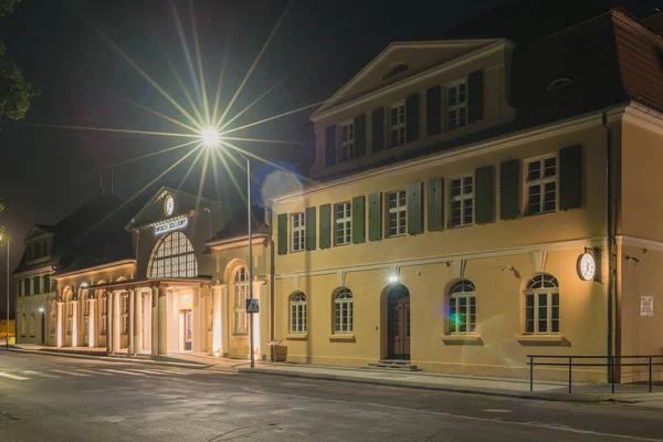 Polonya 'nın Zagan kentindeki tren istasyonunun tarihi binası. Fotoğraf gece çekildi. Karanlık, elektrik fenerlerinin ışığıyla aydınlanıyor..