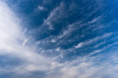 Hafif bulutlu gökyüzü beyaz bulutlarla kaplı. Bulutlar güçlü jet akıntıları tarafından tırtıklı kurdelelere gerilir..
