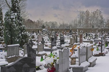 Karlı kışta bir mezarlık. Mezarlıkta büyüyen mezar taşları, sokaklar ve haydutlar bir kar tabakasıyla kaplıdır..