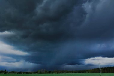 Karanlık, uğursuz bulutlarla kaplı. Bulutlar dalgalı, koyu mavi renkli ve yaklaşan fırtınayı duyuruyorlar..