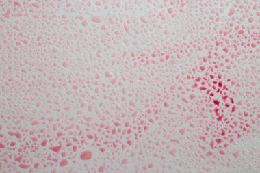 Gri arkaplanda kırmızı renkli su damlaları, soyut doku, yumuşak odak. 