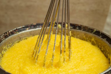 Dökme demir bir tencerede mısır unu kaynatmak, Mamaliga yapmak, geleneksel Romanya yemekleri, ve paslanmaz çelik çırpıcı ile karıştırmak, yumuşak odaklanma