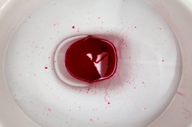 Ceramic toilet bowl with bloody red paint representing serious medical symtom