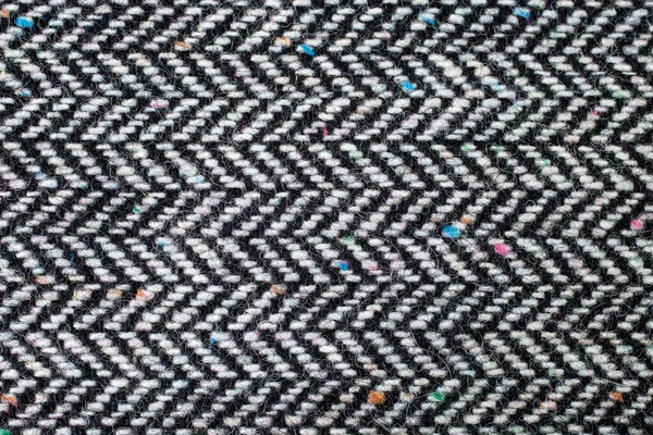 Herringbone, also called broken twill weave, a distinctive V-shaped weaving pattern usually found in twill fabric. Soft focus close up