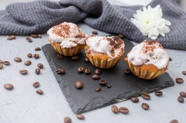 3 home made cupcakes on a black stone tile, soft focus close up