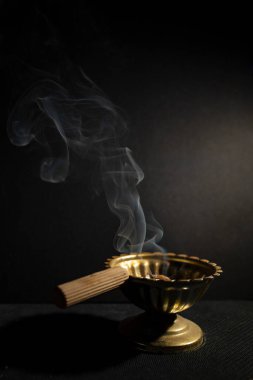 A simple Romanian orthodox censer or incense burner , soft focus close up, dark moody background