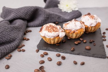 3 home made cupcakes on a black stone tile, soft focus close up
