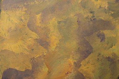 Orange and purple colors smudged on leather texture, abstract autumn backdrop,  soft focus close up.