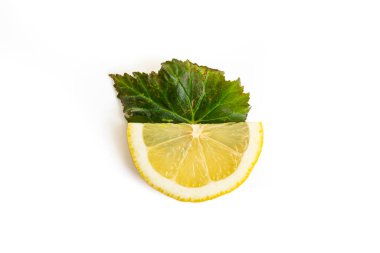 Half of a lemon slice on a green leaf isolated on white background
