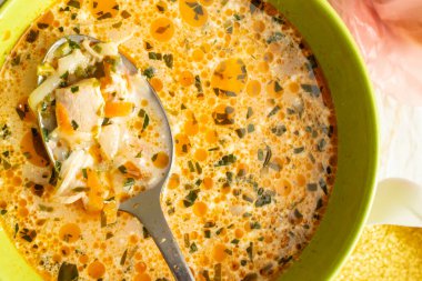 İnce doğranmış sebzeli tavuk çorbası ve paslanmaz çelik kaşıklı yeşil kalp, dokuyu kapat.