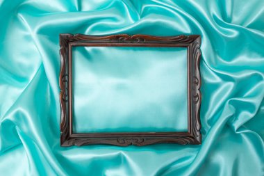 Güzel mavi ipeksi saten. Yumuşak kıvrımlı parlak kumaş ve eski ahşap çerçeve.  