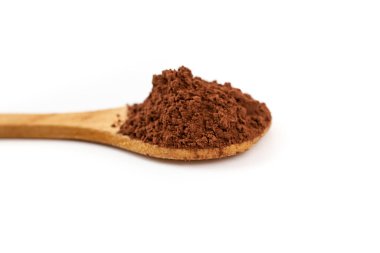 Tahta bir çay kaşığında kakao tozu yığını, beyaz arka planda izole edilmiş, yumuşak bir odak.