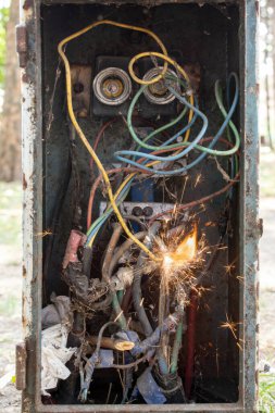 Kirli kabloları, kıvılcımları ve alevi olan eski sigorta kutusu, kısa devre konsepti