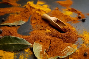 Dağınık baharatlar ve koyu yapraklar siyah arkaplanda, yumuşak odaklanma yakın