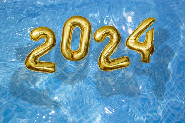 2024 Su dalgaları yüzeyindeki şişme altın sayılar, yüzme havuzu konseptiyle mutlu bir yeni yıl.