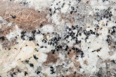 Çatlaklar ve çizikler olan aşınmış bir mermer parçasının makro fotoğrafı. 